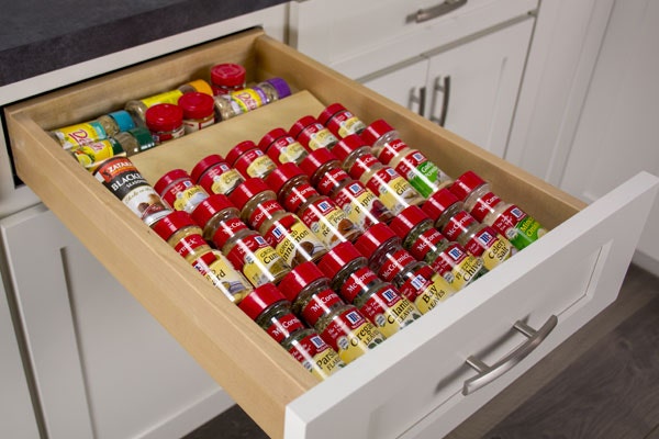 A drawer with a spice drawer insert, filled with spices.