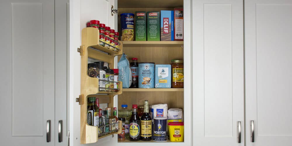 door mounted spice rack placed on the inside of a cabinet.