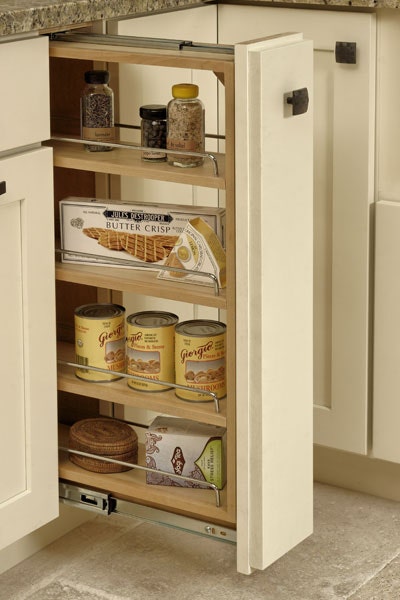 Base pull-out storage cabinet with three shelves storing cans, crackers, tea, and herbs