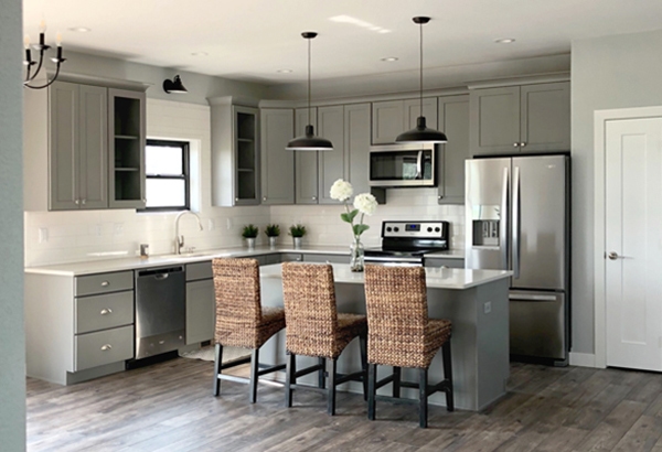 open l-shaped kitchen with island seating, gray kitchen cabinets and black light fixtures