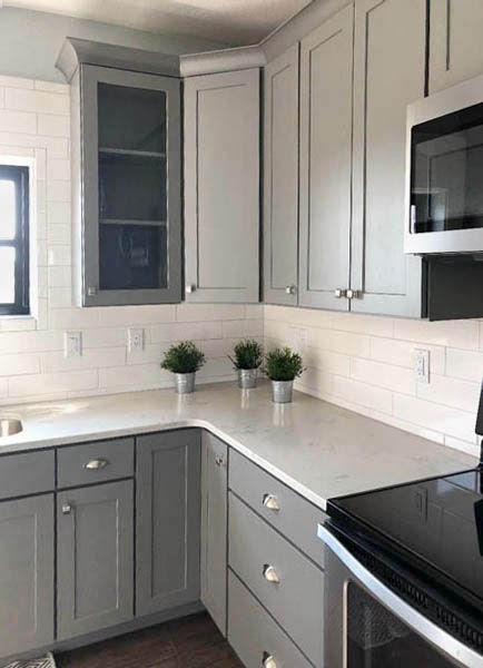 Glass kitchen cabinet doors in medium gray surround kitchen sink