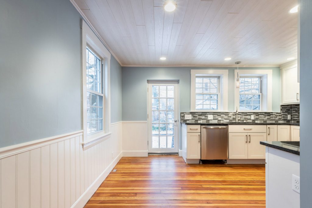 Kitchen with white cabinets and small eat-in dining area near back door