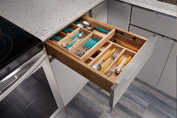 Tiered drawer insert in Slab door and Painted medium Gray with the second tier storing silverware open revealing the layer underneath