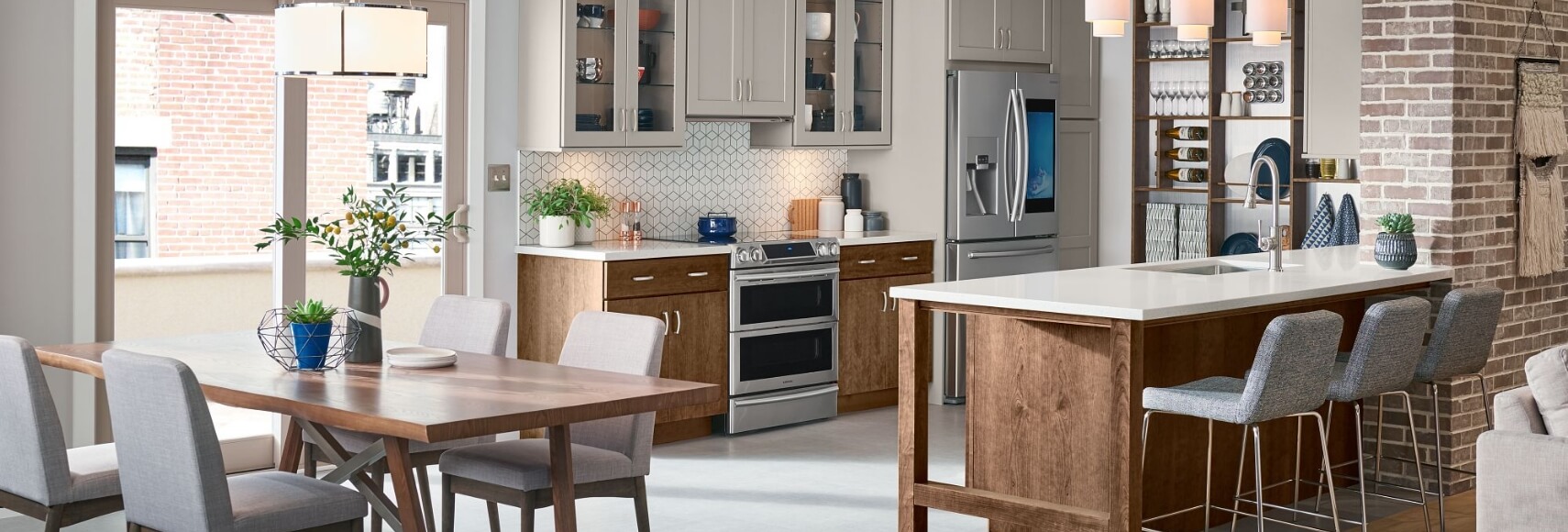 One-wall kitchen design with white shaker wall cabinets and medium wood base cabinets and a kitchen island.