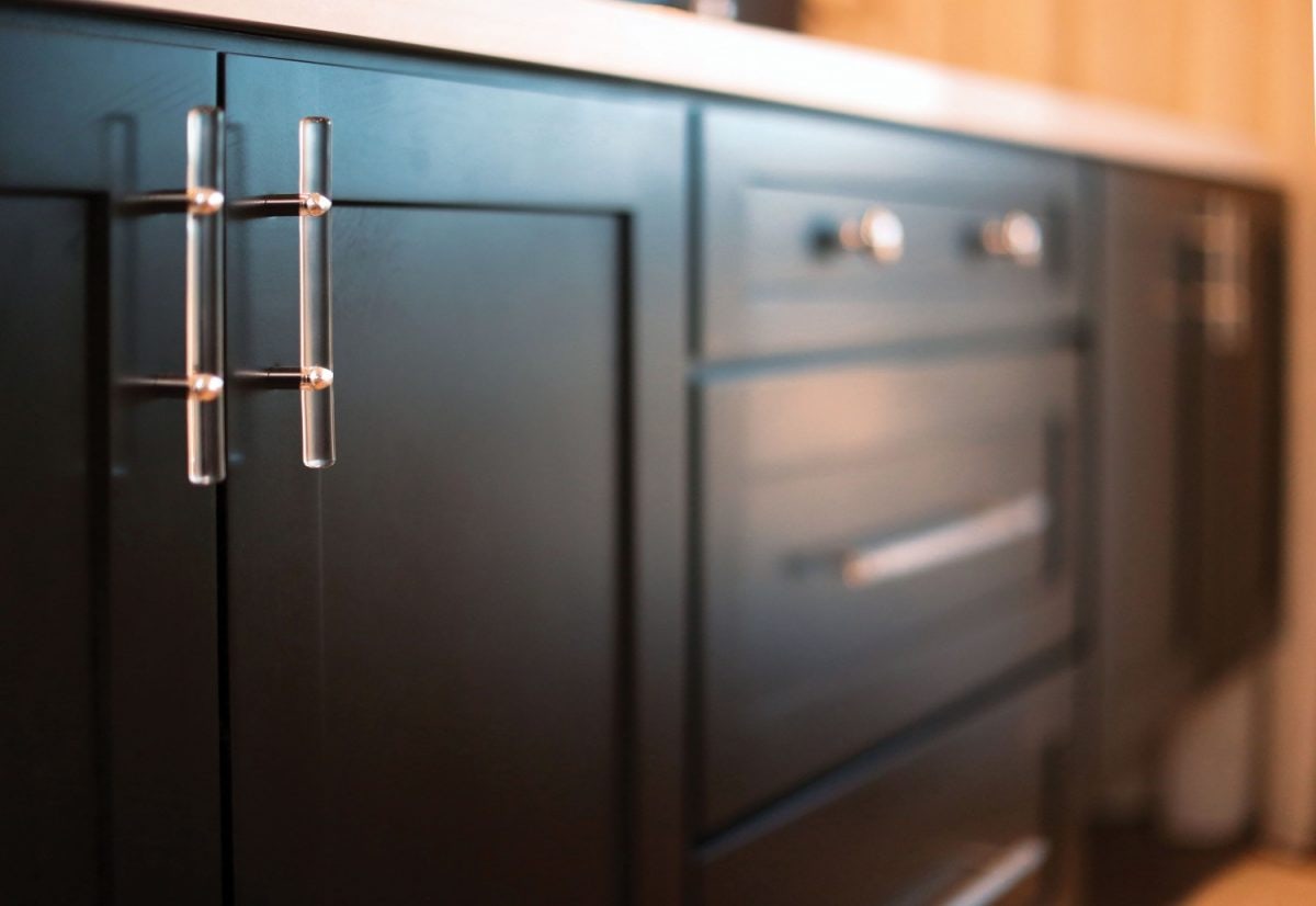 Black vanity cabinet with two sinks and drawers inbetween.