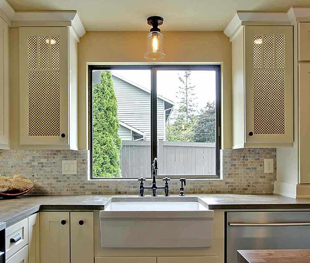 kitchen window with open cabinets on either side featuring metal grid inserts