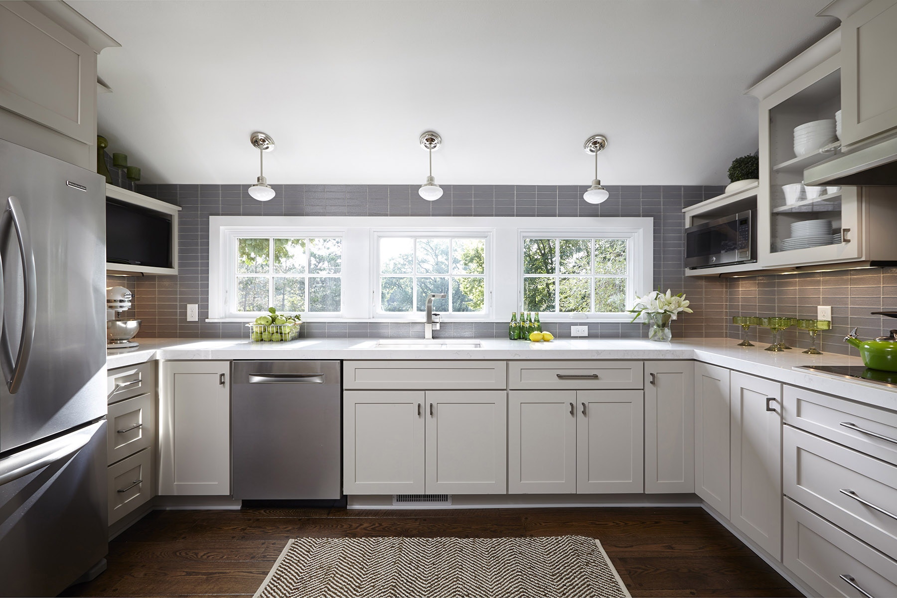 Gray kitchen with shaker cabinets and large bank of windows