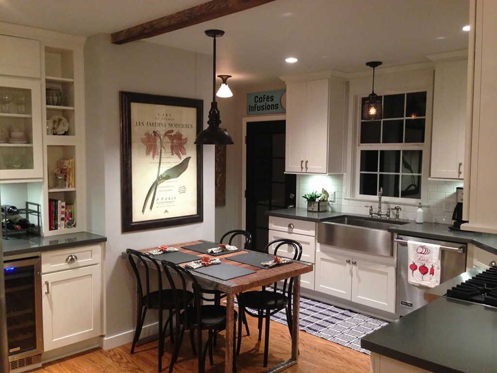 Burbank, California, remodeled kitchen has white Shaker cabinets, built-in desk and hutche, vintage table and chairs and oiled black pendant lamps