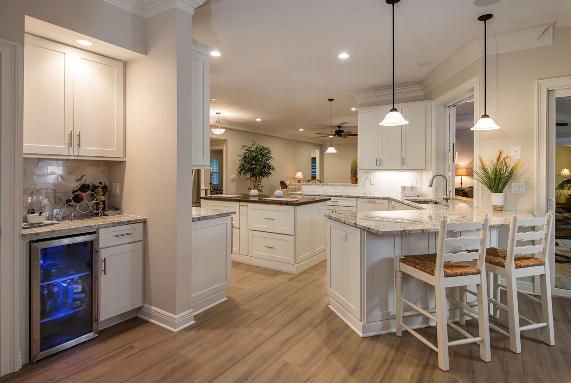 peninsula breakfast bar in white shaker cabinets in open kitchen with furniture look island