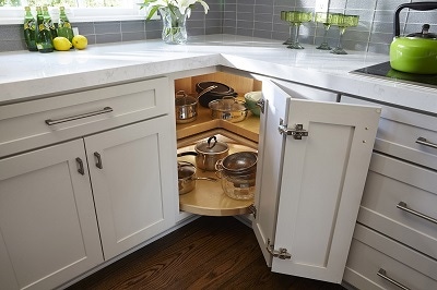 closeup of light gray shaker cabinets with lazy susan base open to display turntables