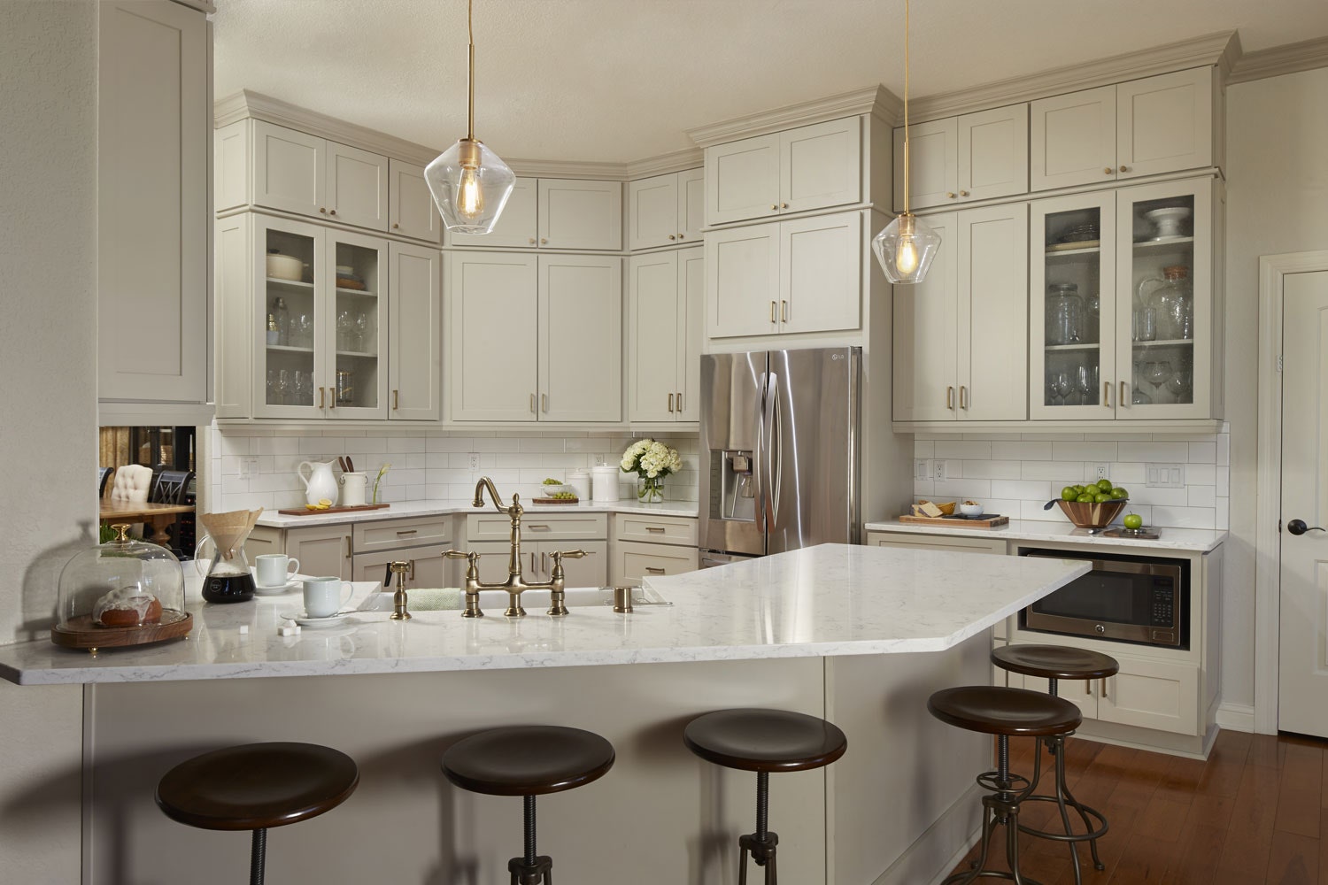 Transitional gray kitchen remodeled with white countertops and glass cabinet doors