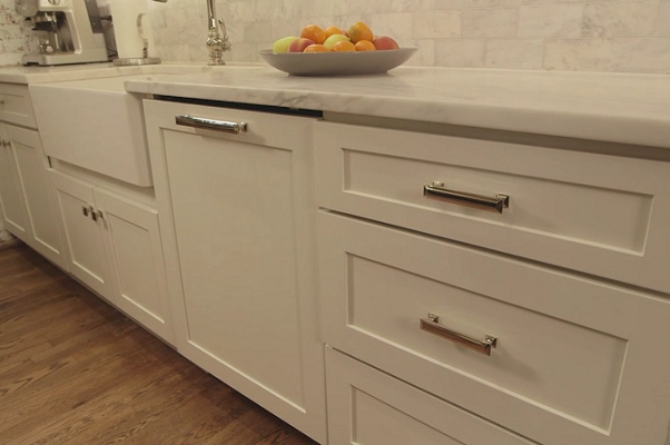 white shaker kitchen cabinets with farmhouse sink and decorative dishwasher panel