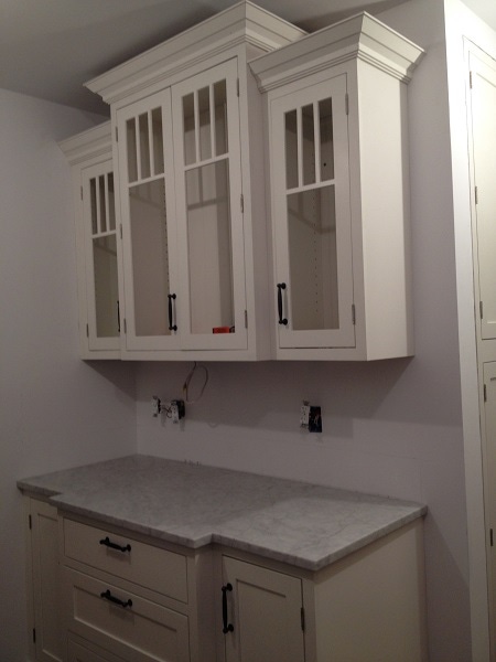 buffet built of white shaker cabinets with glass doors and crown molding