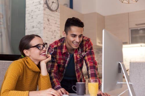 Smiling couple looking at their computer