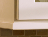 corner of white wall cabinets trimmed with light rail to conceal under-cabinet lighting