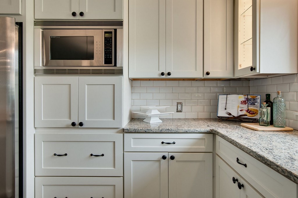 White shaker stacked kitchen cabinets with built-in microwave