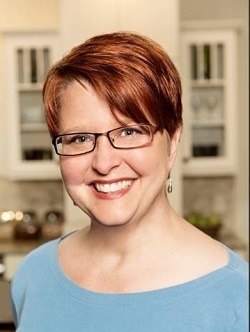 portrait of kitchen designer Rachel Brune, a young woman with short red hair and glasses