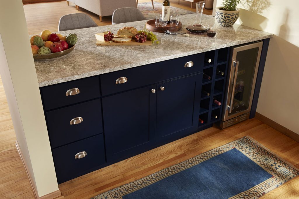 Blue base cabinetry with stainless cup pulls and knobs, cambria countertops, minifridge and wine cubes