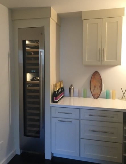 Wine cellar cabinet in butlers pantry with cabinet created from white shaker cabinetry