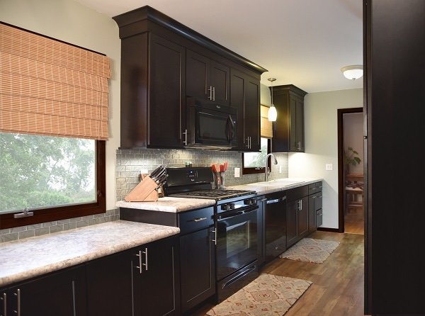 Wall of dark birch shaker cabinets includes a built-in buffet created by a lowered counter under window