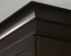 close up view of espresso birch cabinets shows stacked crown molding, simply styled with cove and ogee