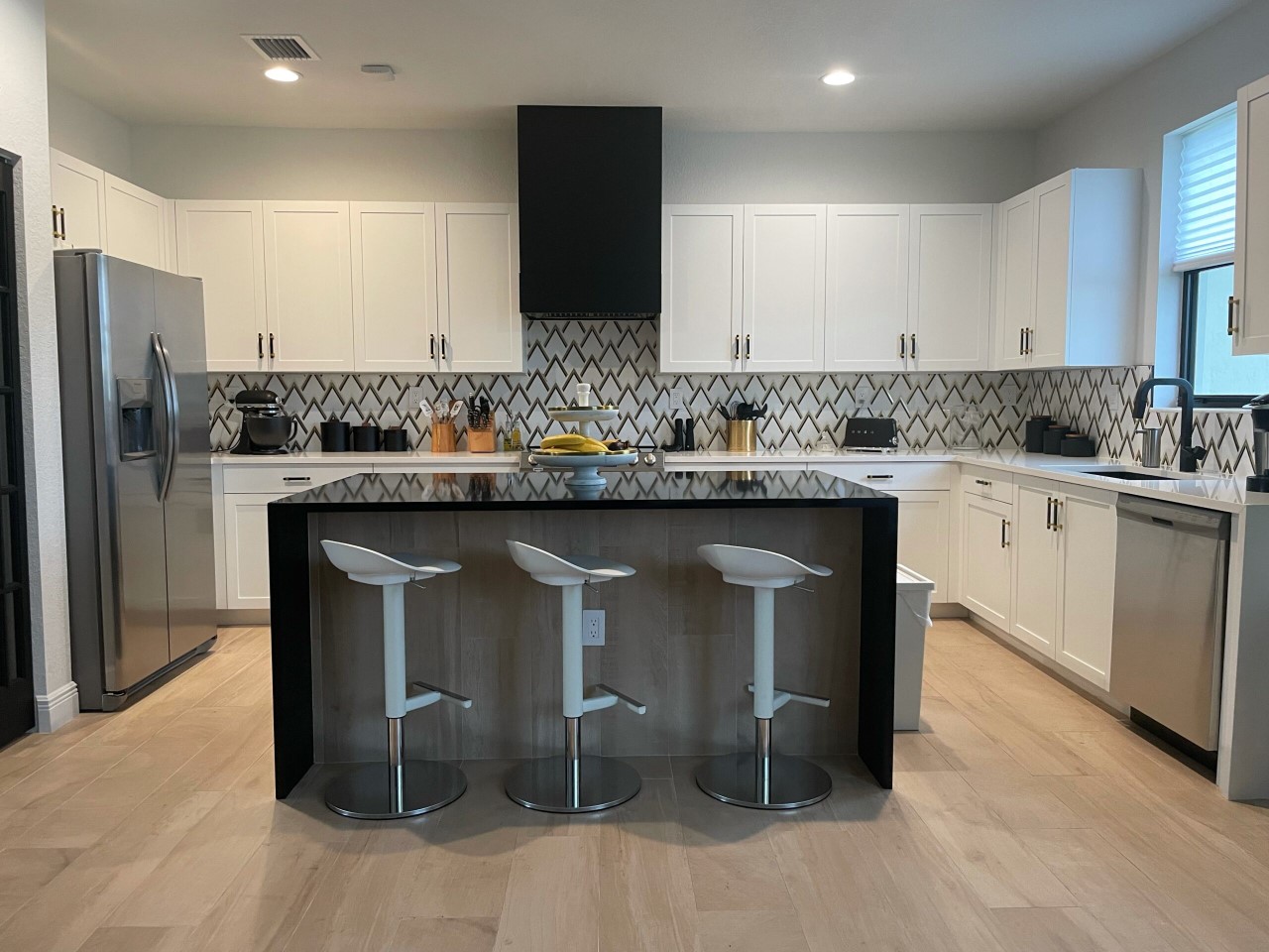 White kitchen cabinets with box shiplap wood kitchen hood in black finish