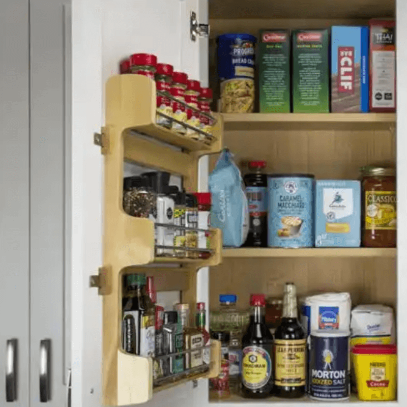 Wall door spice rack with three wood shelves and chrome rails for spices. 