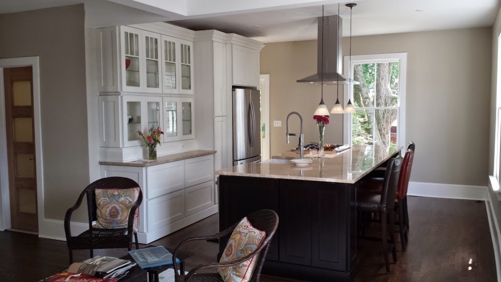 kitchen with white glass door cabinets in buffet and black shaker cabinets in island